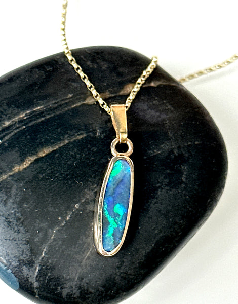 9 Carat Gold Solid Black Opal Pendant Necklace featuring deep blue opal with neon flashes on a gold chain.