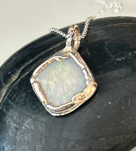 Coober Pedy opal pendant necklace featuring a unique pale blue opal set in textured silver and copper.