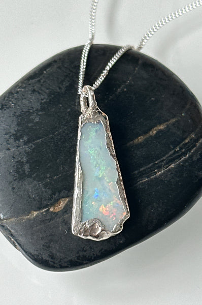 Solid Coober Pedy opal silver pendant necklace featuring milky grey and rainbow colors on textured copper setting.