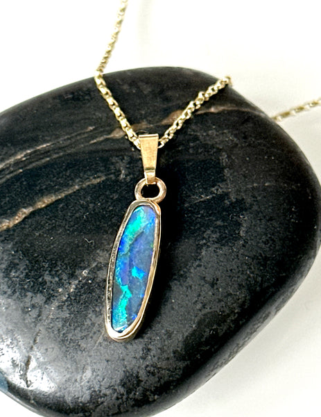 9 Carat gold pendant necklace featuring a solid black opal with blue and green flashes on a stylish chain.