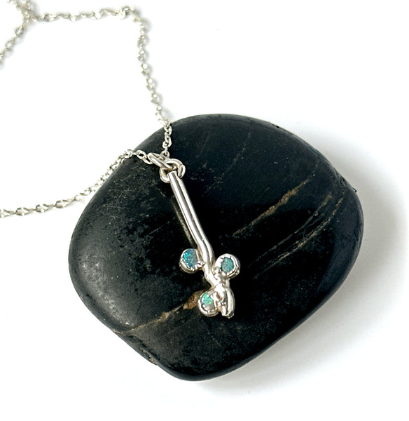 Lightning Ridge opal sterling silver pendant necklace on a black stone background.