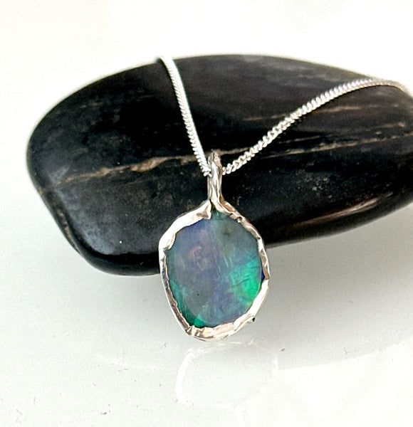 Hand-cut Lightning Ridge opal pendant necklace in silver setting with vibrant blue, mauve, and green tones.