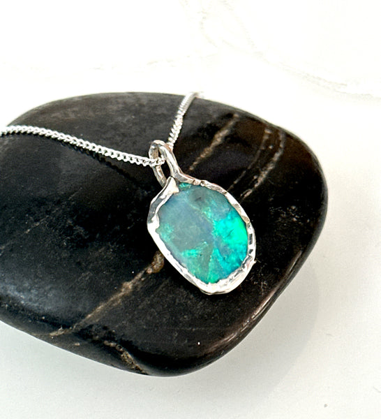 Lightning Ridge opal silver pendant necklace with vibrant neon green hues on textured silver setting.