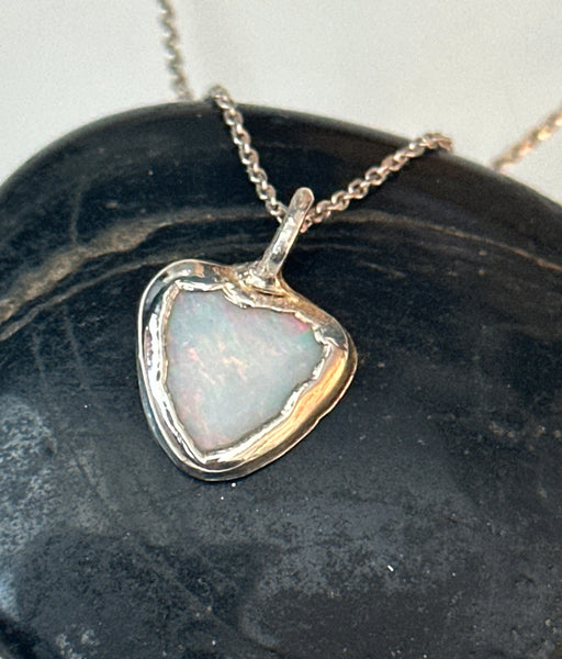 Coober Pedy opal silver pendant necklace featuring a pale blue triangular opal set in textured copper and silver.