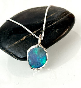 Lightning Ridge opal silver pendant necklace showcasing vibrant blue and green hues on black stone background.