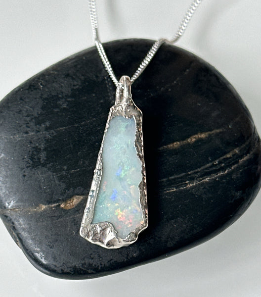 Solid Coober Pedy opal silver pendant necklace showcasing milky grey tones and rainbow color flashes.