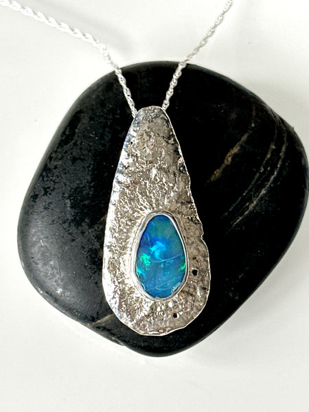 Lightning Ridge opal pendant necklace featuring a vibrant blue/green opal set in a unique textured sterling silver design.