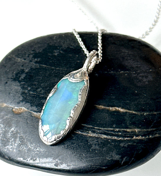Solid Mintabie opal silver pendant necklace featuring blue and green flashes on a textured silver setting.